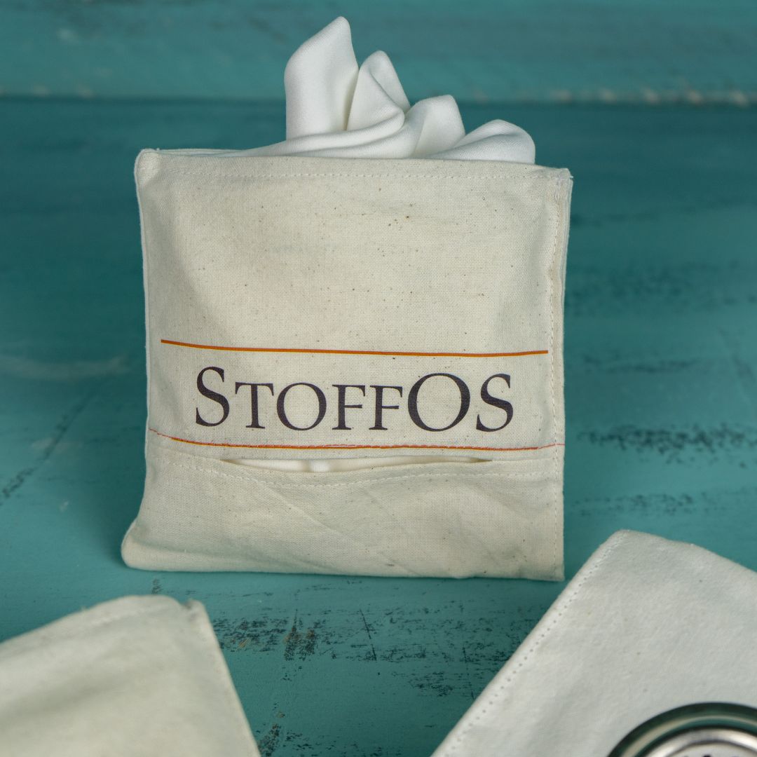 Hier ist der allererste Protoyp der StoffOS To Go Tasche zu sehen. Aus dem vorderen Einfüllfach schauen die Ecken der vier Stofftaschentücher heraus, um zu zeigen, was der Inhalt der Tasche ist.Für dieses Modell wurde erst unsere Markeneintragung bestätigt und danach das Schutzmarkenrecht für die Tasche,. denn die Tasche mit den vier Fächern haben wir selbst entwickelt.