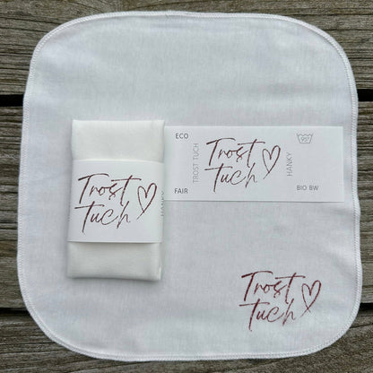 eine Tuch flach liegend in Gr. S 22,5 x 22,5 cm mit BAnderole, auf der Pflegeanweisungen, Trosttuch und Hanky aufgedruckt sind, ein StoffO gefaltet, hochformat, mit Papierbanderole umwickelt, mit dem Tuchdruck-Motiv bedruckt.